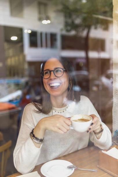 istock Young woman drinking hot beverage in cafe 2156340339