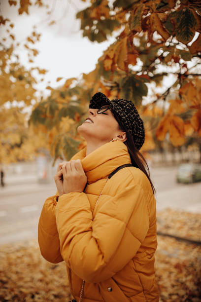 istock Smiling woman touching leaves on autumn tree 2156340342