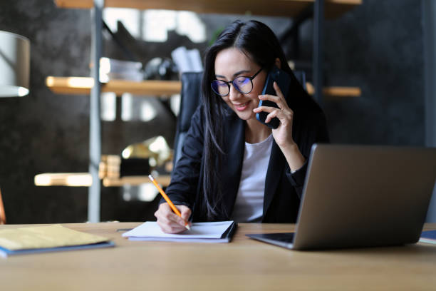 istock Successful entrepreneur, a woman, conversing on smartphone in corporate workplace. 2156344613