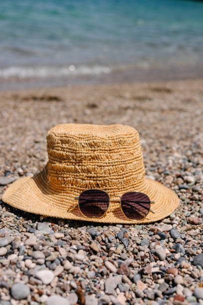 istock Straw hat and sunglasses on the seashore 2156346091