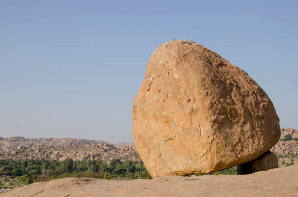 Mahabalipuram, India - October 3, 2023. Visitors stand under Krishna's Butter Ball in Mahabalipuram, a seaside town in Tamil Nadu, India.