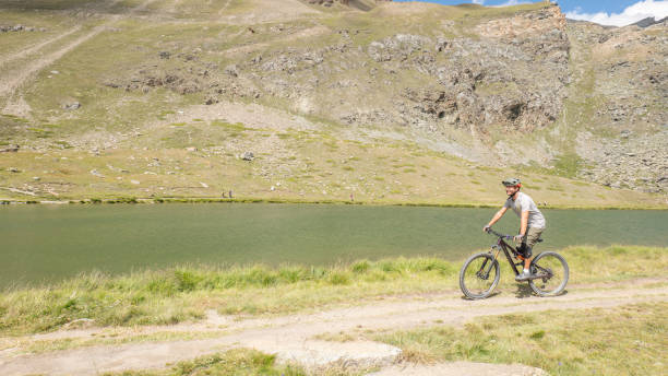 istock Mountain Biker Riding Along Alpine Lake 2156346414