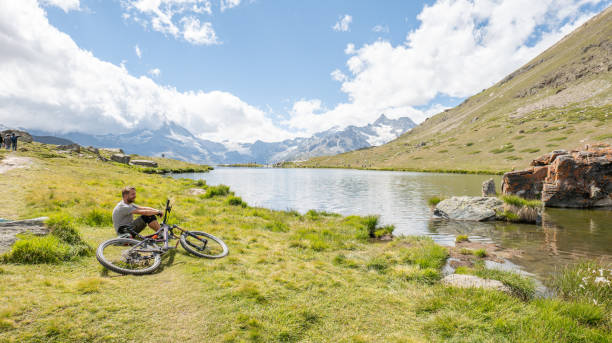 istock Mountain Biker Resting Beside Serene Alpine Lake 2156346591