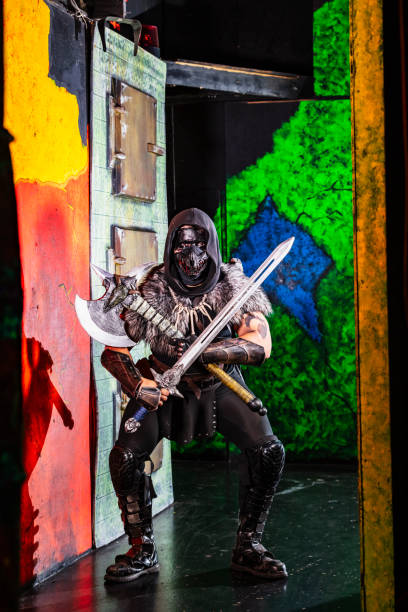 Halloween Haunted House. A young man dressed as a creepy character, the Grim Reaper, walking in through a doorway.