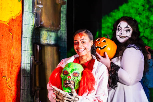 Halloween Haunted House. Two young women in costumes, smiling at the camera.