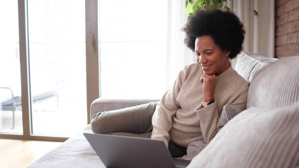 istock Woman relaxing on the sofa and surfing the net 2156350350