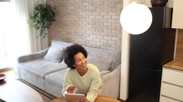 istock African woman adjusting smart home system 2156351206