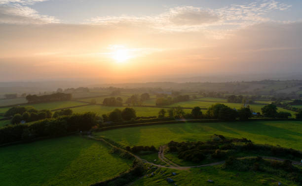Early morning sunlight reveals the misty landscape of Dartmoor National Park.