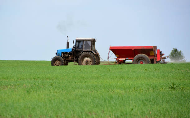 istock a blue tractor is driving through a field with a red plow 2156354851