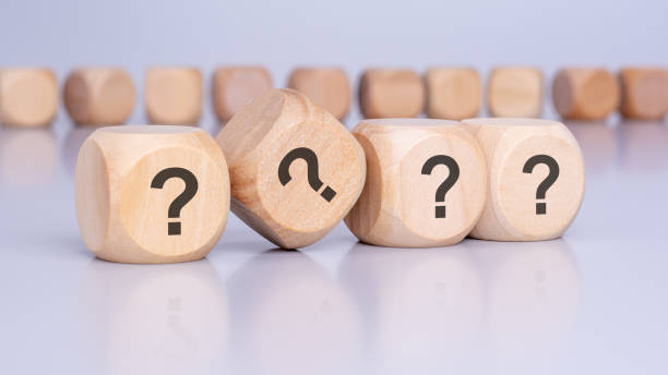 istock four wooden blocks with question marks over a brown background with copy space 2156355284