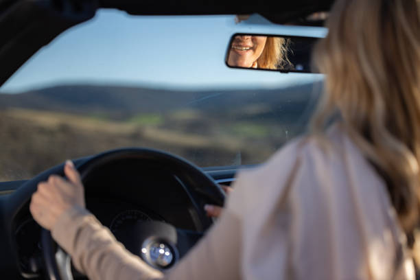istock Woman's teeth in the rear view mirror while sitting in the car 2156356556
