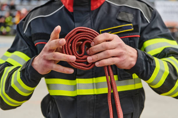 istock Professional Firefighter Cleaning Up Fire Hose After Extinguishing Blaze 2156357540