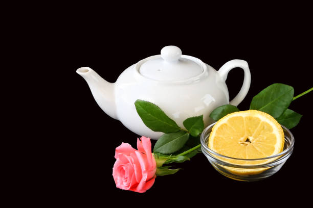 istock Teapot, lemon slice and rose flower still life. Isolated on a black 2156361596