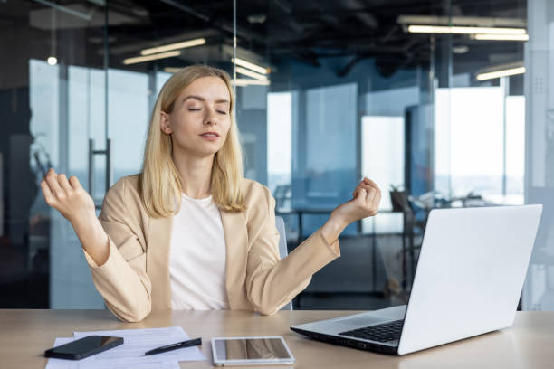 istock Professional woman meditating at desk in modern office 2156361613