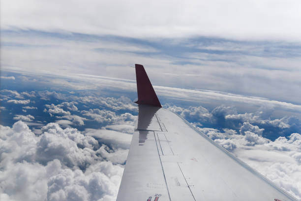 Commercial airplane while flying against a clear blue sky in motion with copy space. Looking through the plane window.