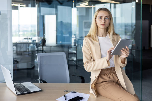 istock Professional businesswoman with tablet in a modern office setting 2156362698