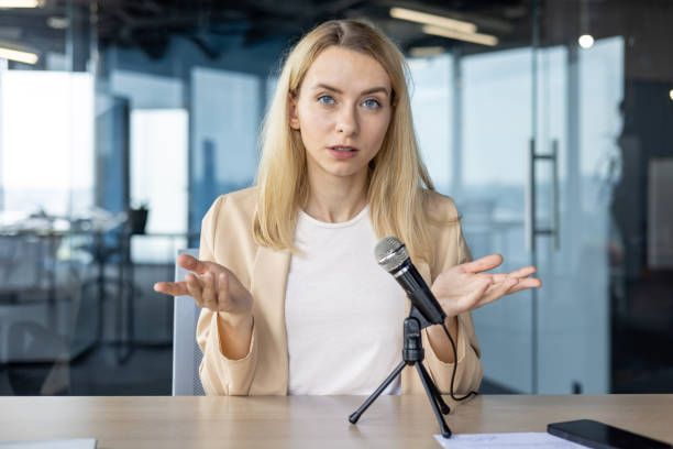 istock Professional woman talking in podcast recording at modern office 2156362915