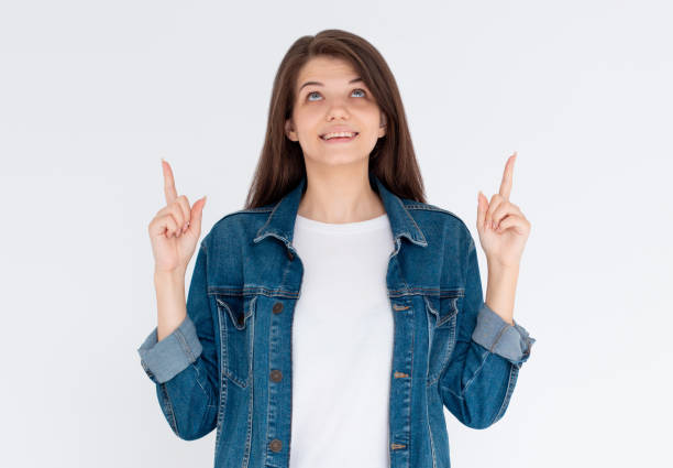 istock Pretty young brunette in jeans shirt gesturing up with fingers 2156363317