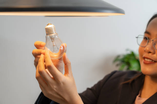 istock The young woman is changing light bulbs at home 2156363399