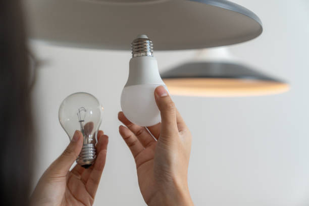 istock The young woman is changing light bulbs at home 2156363407