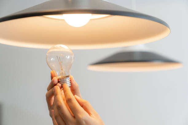 istock The young woman is changing light bulbs at home 2156363456