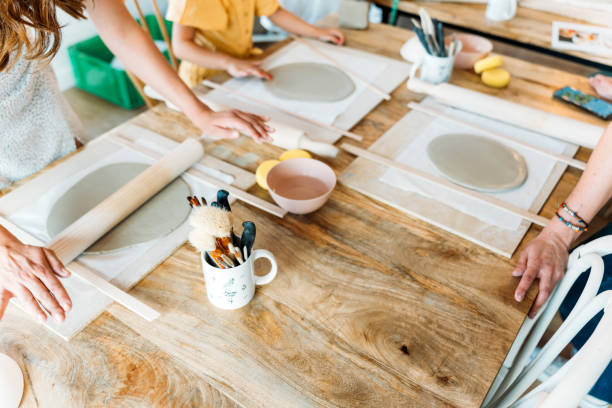 istock Ceramic workshop. Group of friends crafting a ceramic plate. 2156363586
