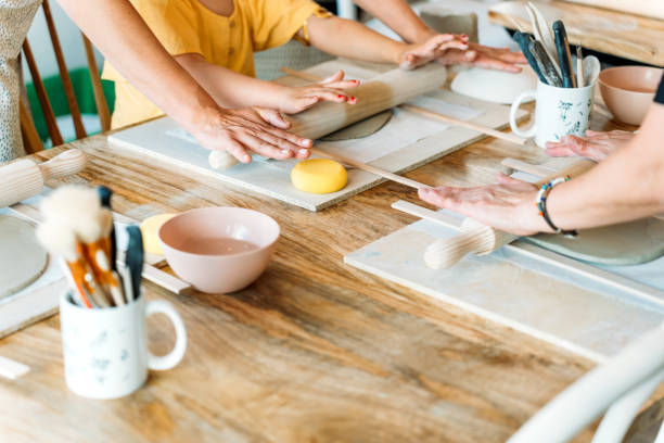 istock Ceramic workshop. Group of friends crafting a ceramic plate. 2156363596