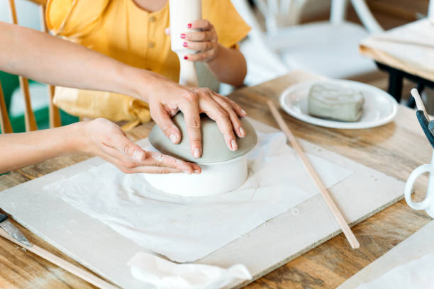 istock Ceramic workshop. Group of friends crafting a ceramic plate. 2156363606