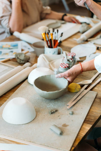 istock Ceramic workshop. Group of friends crafting a ceramic plate. 2156363630