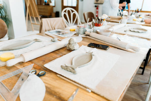 istock Ceramic workshop. Group of friends crafting a ceramic plate. 2156363633