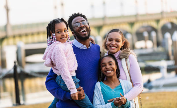 istock Multiracial family  on waterfront smiling at camera 2156363706