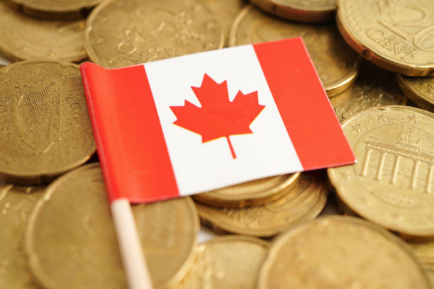 istock Canada flag on coins, finance and banking. 2156364331