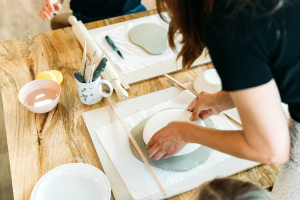 istock Ceramic workshop. Group of friends crafting a ceramic plate. 2156365249