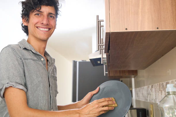 istock Young latin man smiling happy washing dishes at home 2156367295