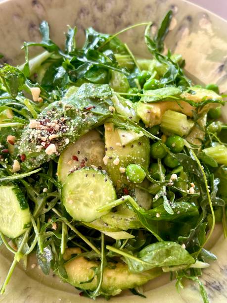 The background photo of a part of a fresh green salad with copy space was taken with a macro lense.