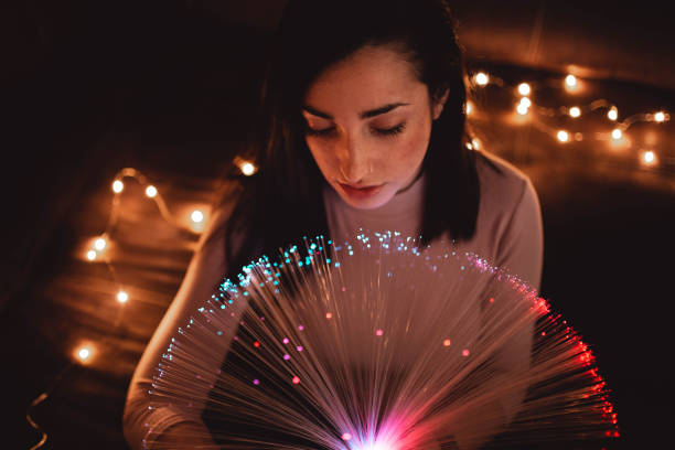 istock Young woman with fairy lights in darkness 2156369321