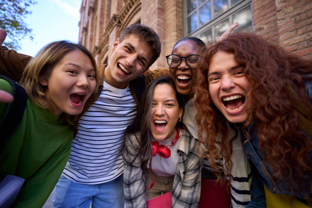 istock Portrait multiracial group student hugging looking excited at camera together at university campus. 2156372588