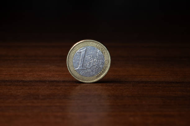 istock a one euro coin stands on a wooden table 2156373565