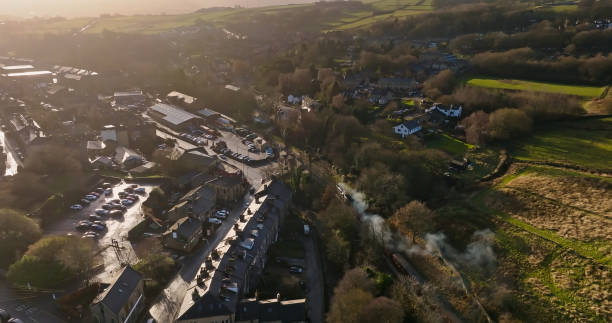 Aerial view of a steam train in the village of Haworth in the Worth Valley in West Yorkshire, England on a hazy day in winter. The village is famous for its association with the Brontë sisters.
