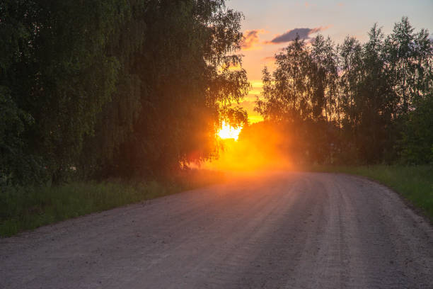 evening orange sunset on a winding country road with dust