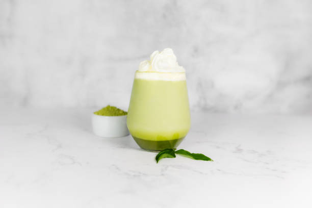 istock Matcha green tea in a glass with whipped cream on a light gray background. 2156379332