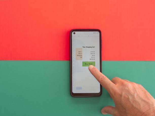 Hand holding smart phone about to make an online purchase with cautionary concept depicted by color division on background.