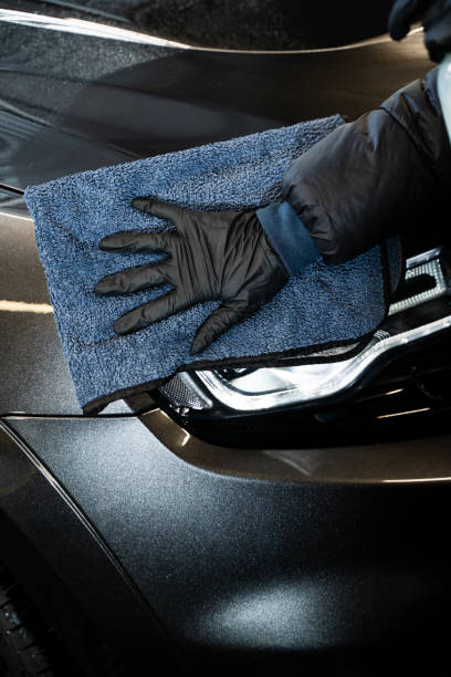 istock Cleaning car using microfiber and quick detailer. Applying spray on car surface and wiping by rag. One of the step of professional car detailing. 2156381060