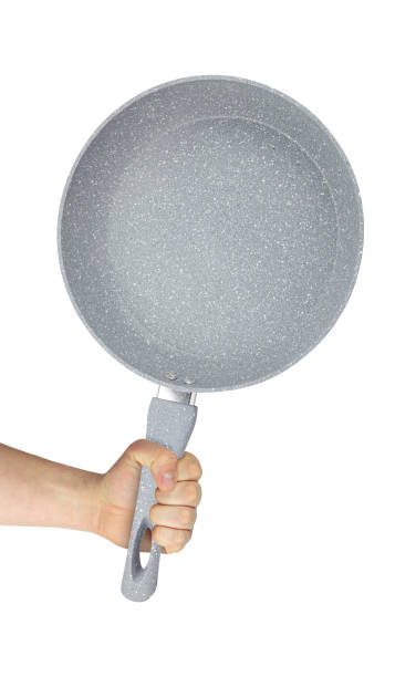 istock frying pan in hand, outstretched hand with frying pan isolated from background 2156381756