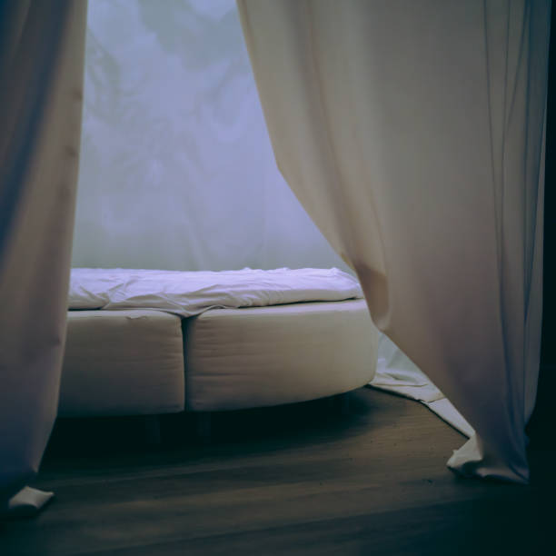 istock slightly opened curtain in front of a round bed 2156383312