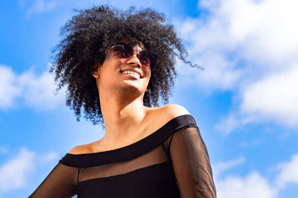 istock Non-binary person with afro hair and sunglasses, smiling 2156385254