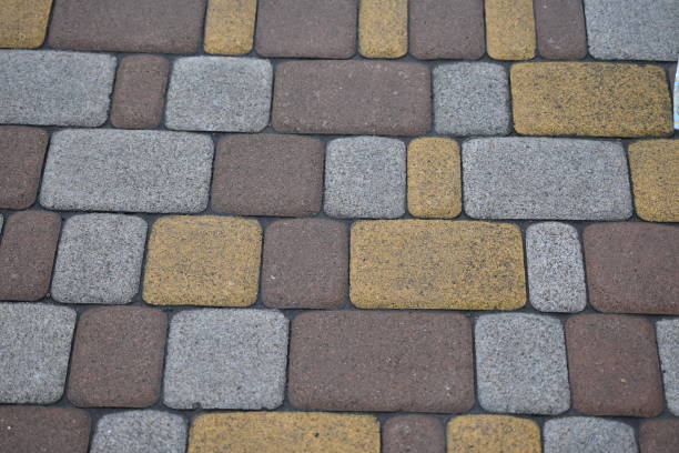 grey paving slabs as a background, yellow symmetrical paving slabs close up