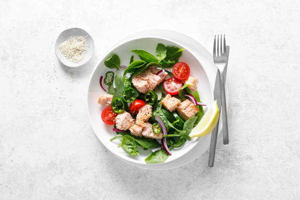 istock Salmon salad with fresh spinach, tomato and green pepper, top view 2156388004