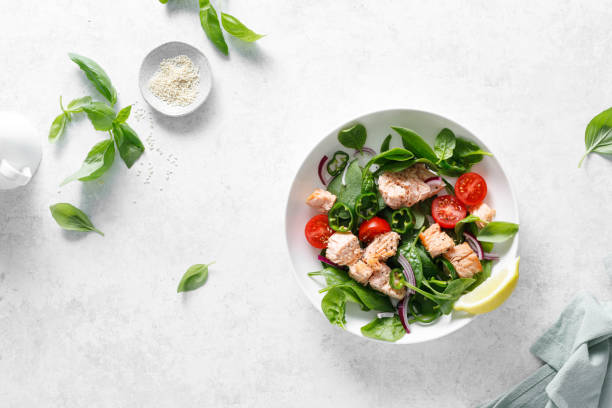 istock Salmon salad with fresh spinach, tomato and green pepper, top view 2156388062