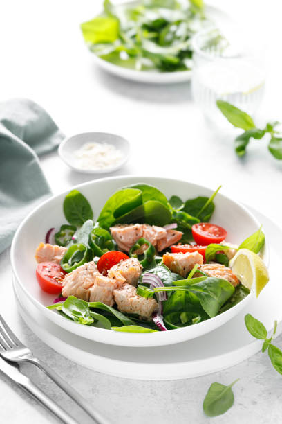 istock Salmon salad with fresh spinach, tomato and green pepper, top view 2156388089